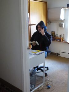 A worker taking calls on a butt phone in a building with no heat and no power for the phone system. 2012-11-01